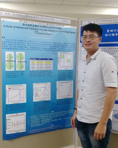 A person standing next to a scientific poster titled 'A Study of Nanoscale Palladium Powder Applied on 3D Printing Process.' The poster presentation contains charts and data related to the research on nanoscale palladium powder in 3D printing.