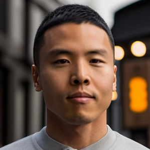 A young man standing outdoors with an urban background, featuring blurred buildings and lights.
