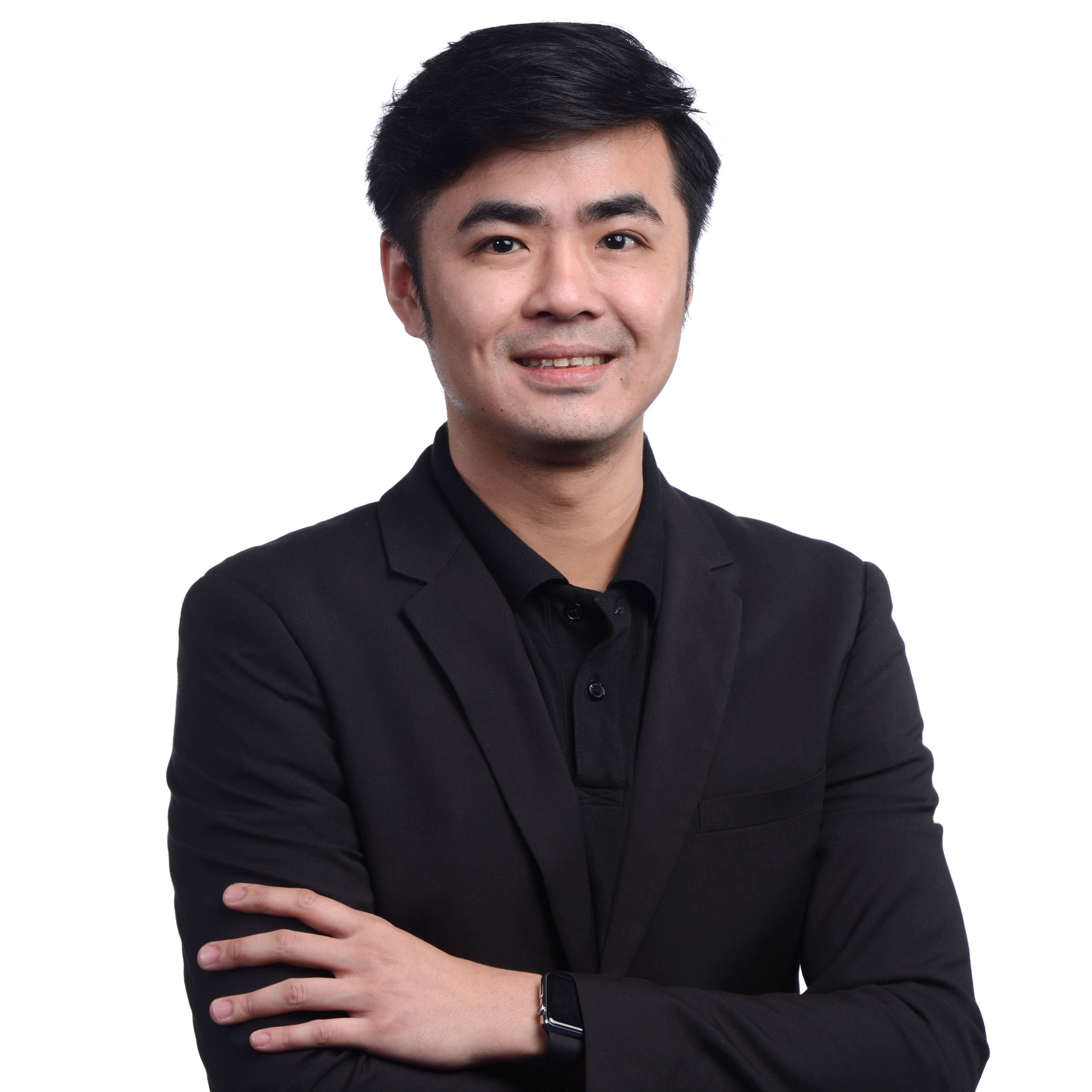 Professional portrait of a man in a black suit with arms crossed, smiling, and posed in front of a white background.