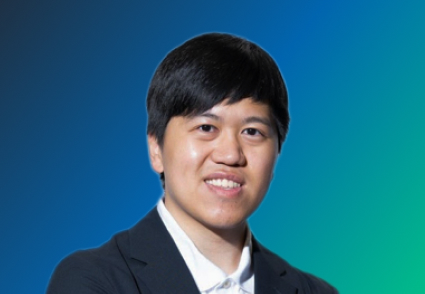 A person in formal attire against a gradient blue and green background.