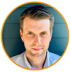 Headshot portrait of a man with light brown hair, blue shirt, and teal background