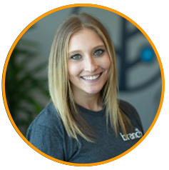 A person wearing a gray "Branch" t-shirt with a blurred background featuring abstract shapes and greenery.