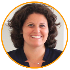 A professional portrait photo of a woman with curly dark hair, smiling and wearing a dark top, set against a white background with an orange circular border.