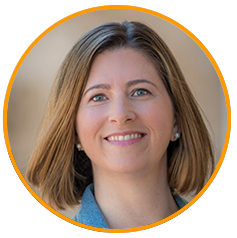 Professional headshot of a woman with straight shoulder-length hair, wearing a blue top, used for Qualtrics marketing campaign.