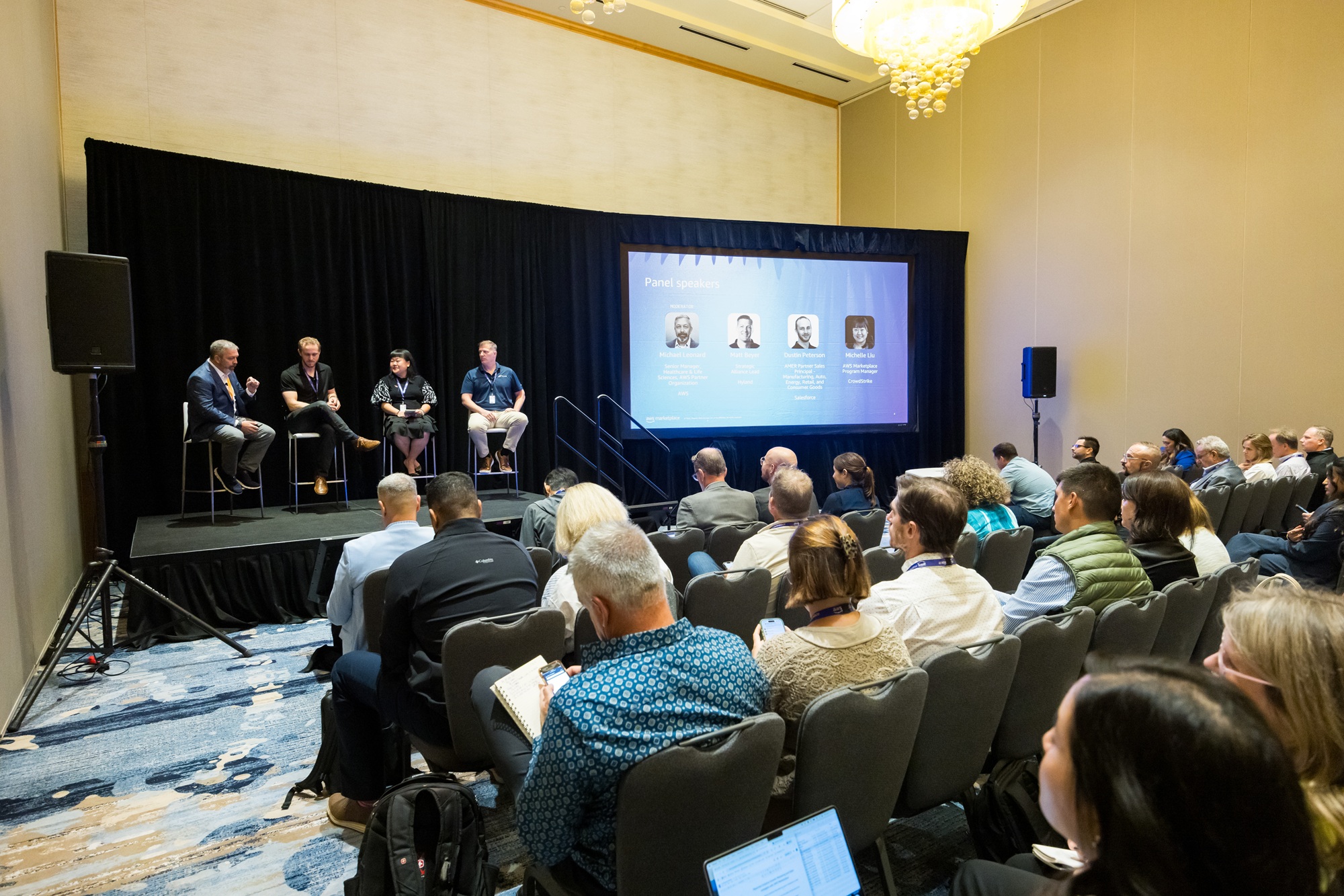 Group of AWS Seller Conference professionals gathered on stage for a Breakout Session with rows of attendees