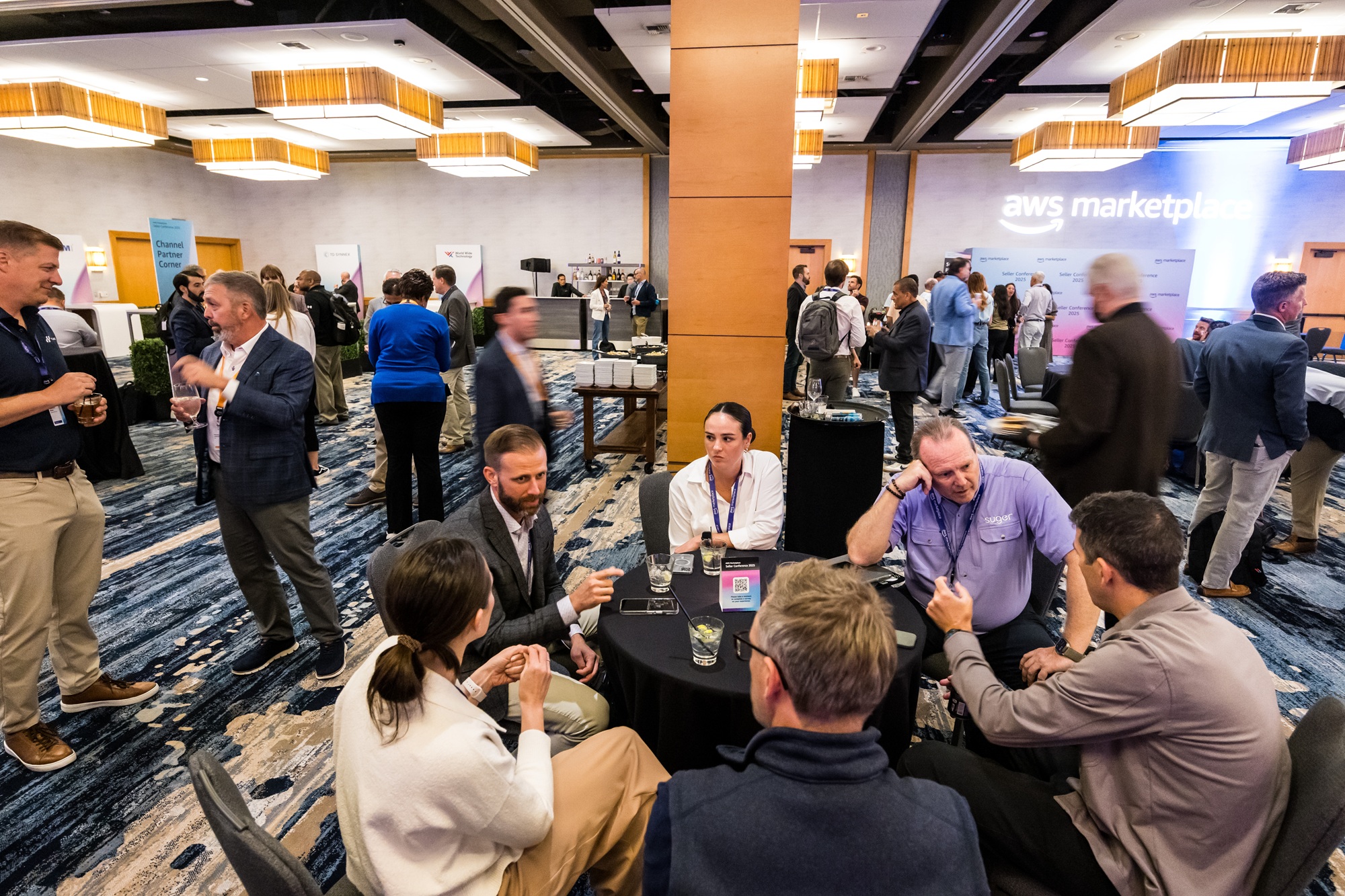 Group of AWS Seller Conference attendees, networking at a roundtable in a conference hall