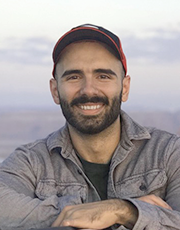 Portrait of a smiling man outdoors wearing a cap and jacket