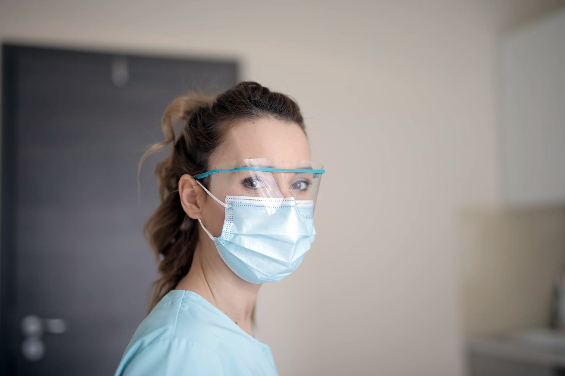 Healthcare worker in protective mask and face shield representing pre trained model applications for medical diagnostics and imaging