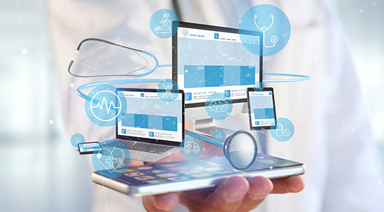 A hand holding a smartphone with holographic images of medical devices, screens, and icons representing digital healthcare technology.