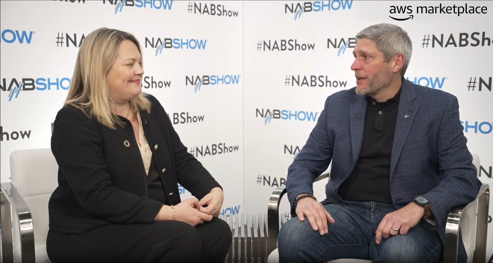 Two people seated and conversing in front of a NAB Show backdrop, with an AWS Marketplace logo in the corner. This image is a thumbnail for a Bitmovin interview at the NAB Show for AWS Marketplace.