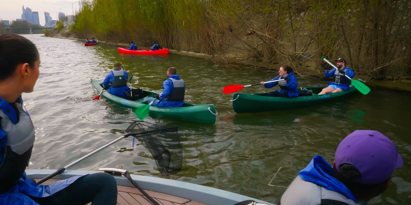 People on the river in canoes in a city in France.