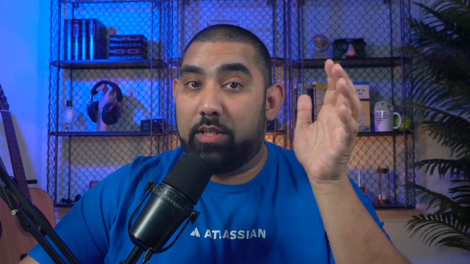 Man in an Atlassian T-shirt speaking into a microphone during a studio recording