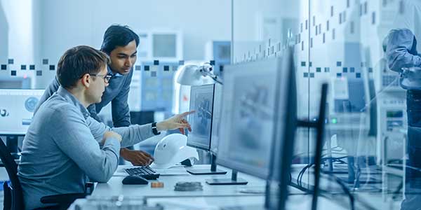 dos hombres trabajando juntos en una computadora