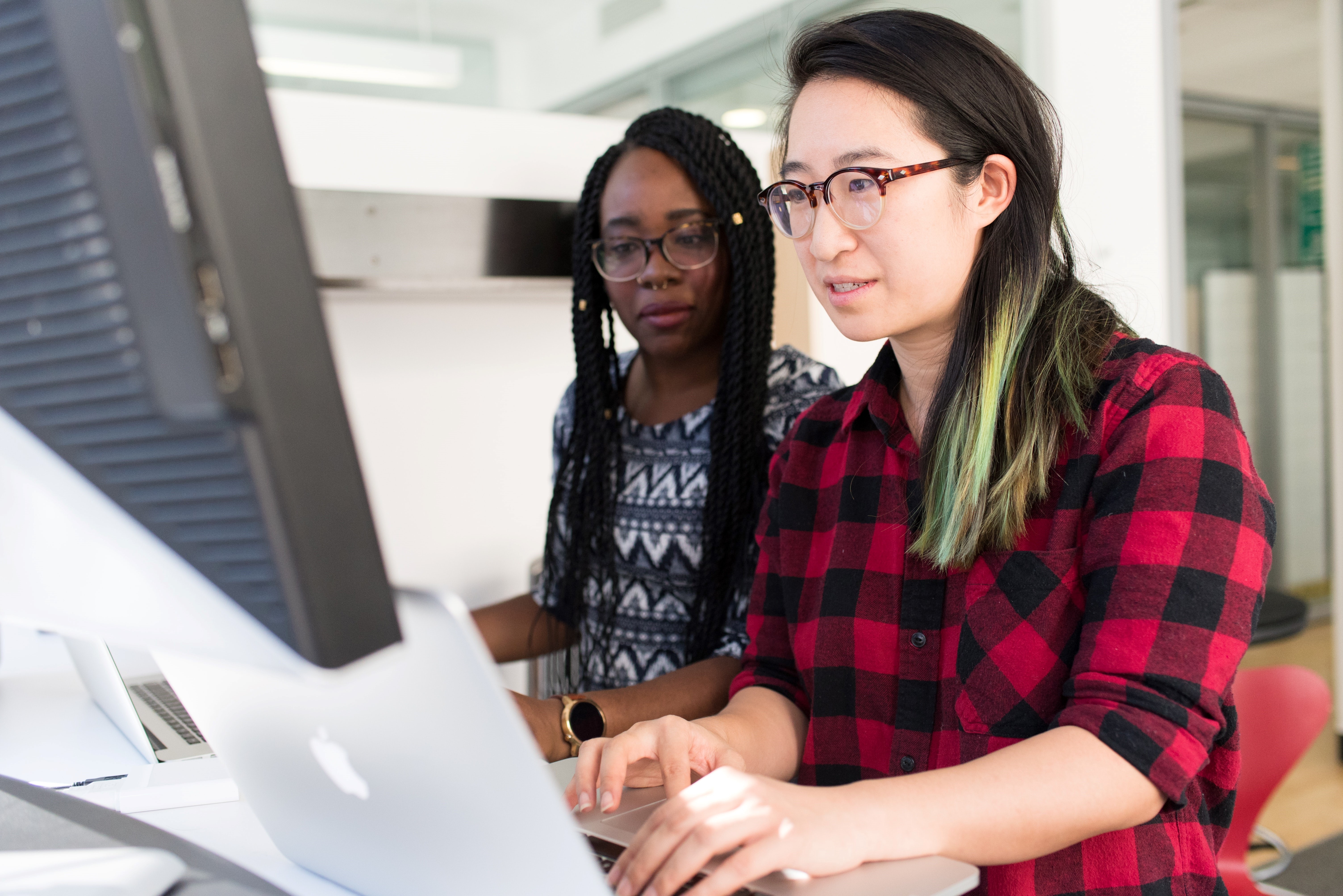 Two female colleagues working on their laptops