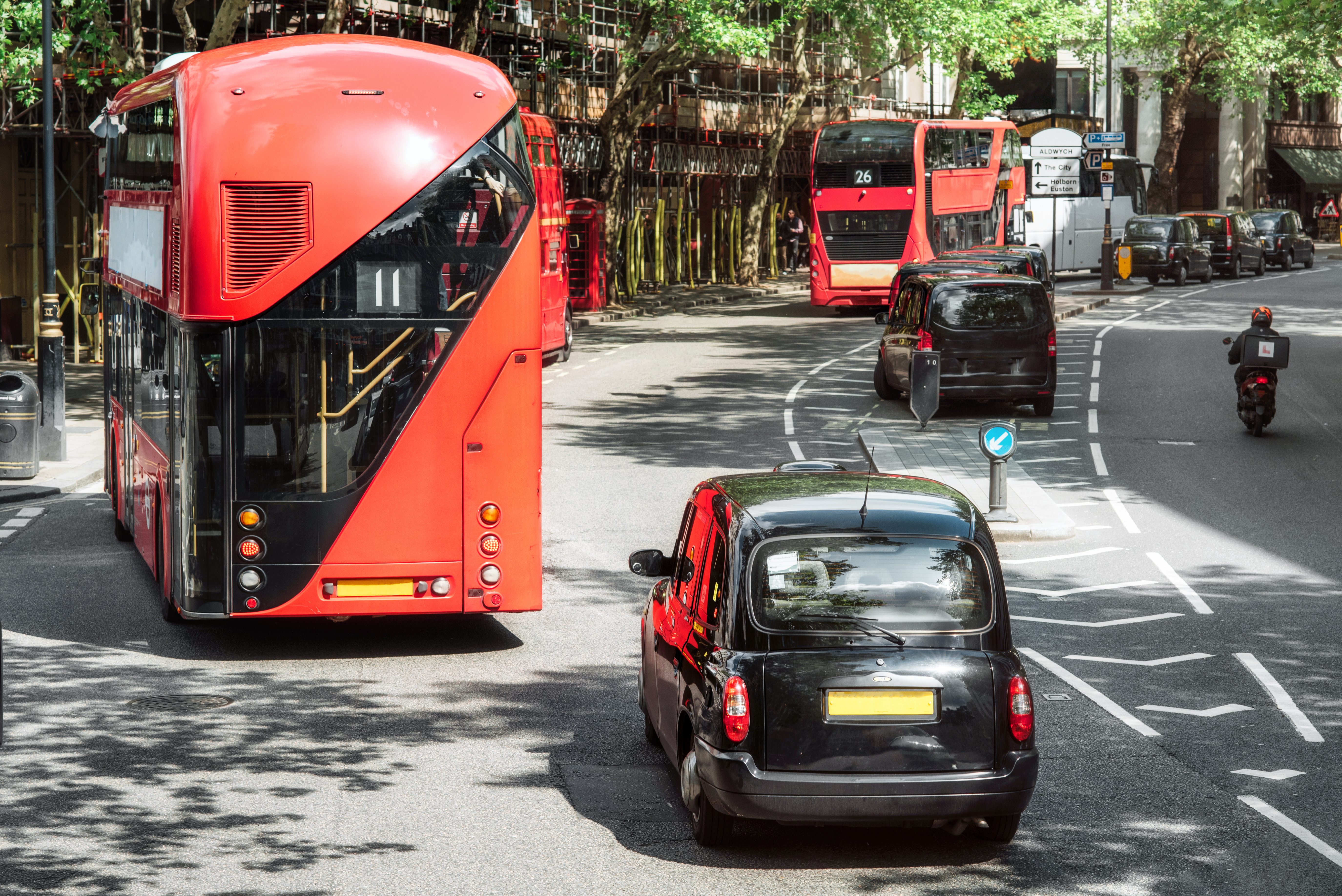 London road traffic, double decker buses and traditional taxi, traditional vehicles of London city.