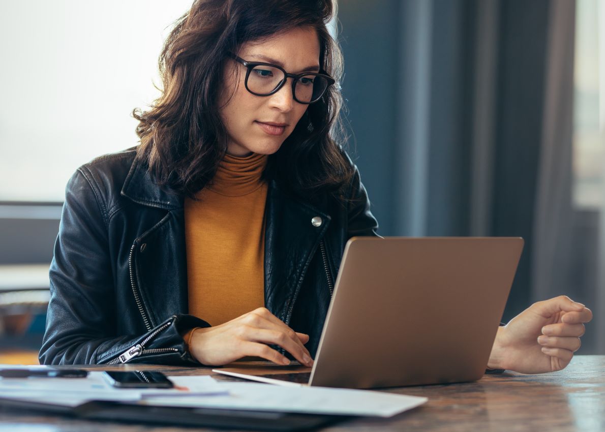 Mulher de óculos trabalhando em um laptop