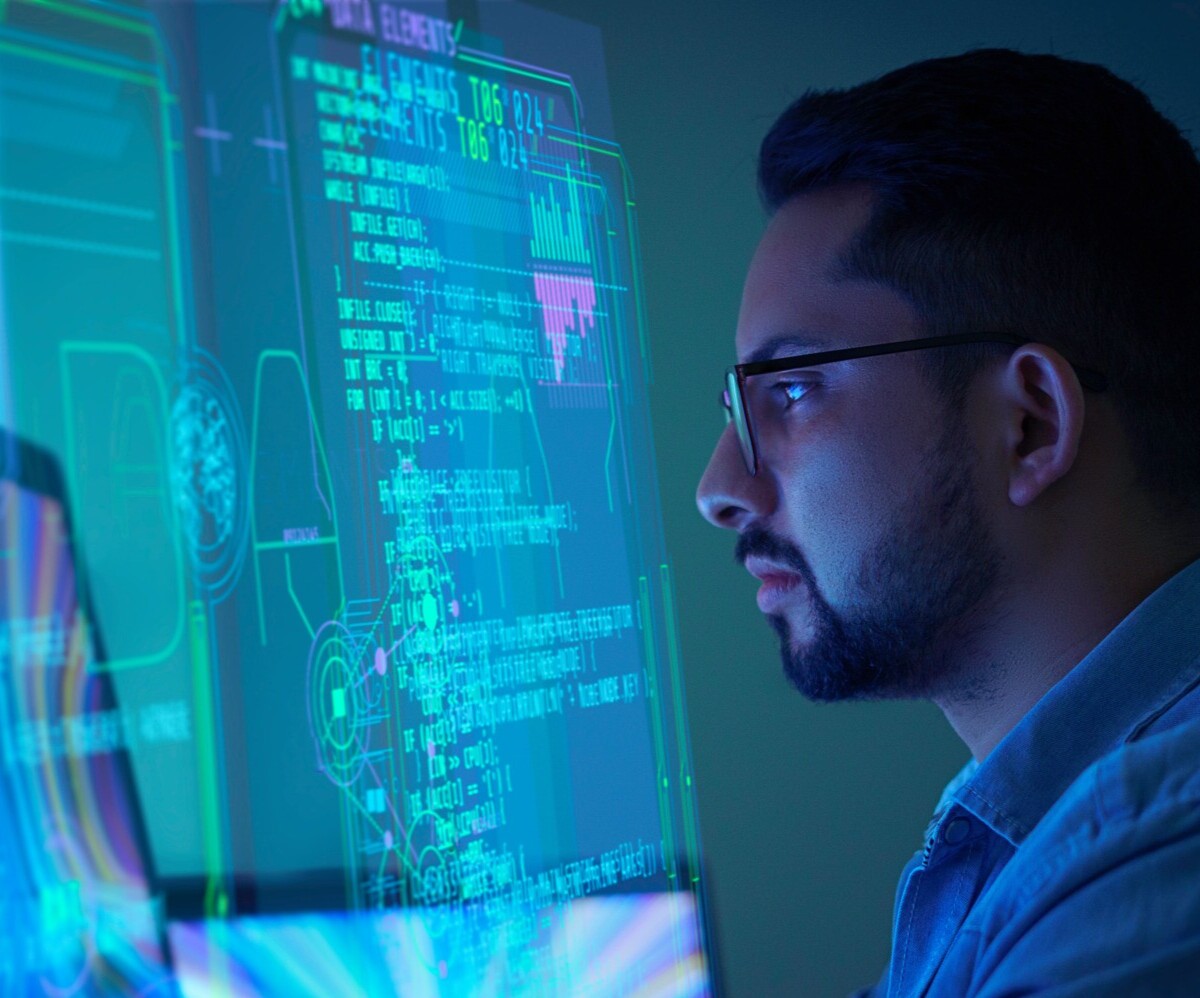 Image depicts a person analyzing data on a computer screen