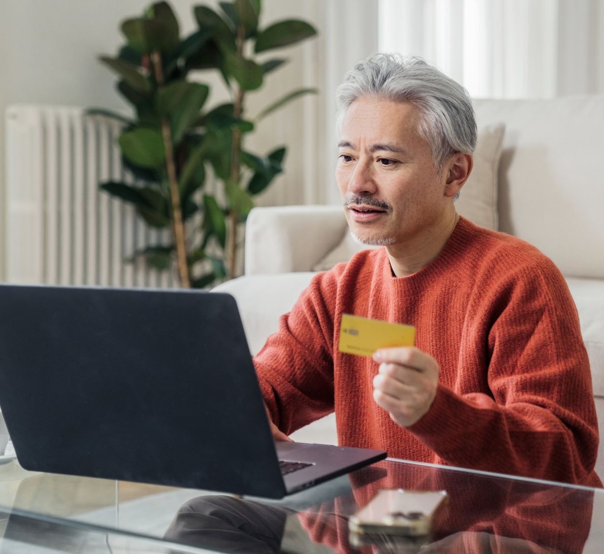 A gentleman managing online payments with a laptop and a credit card