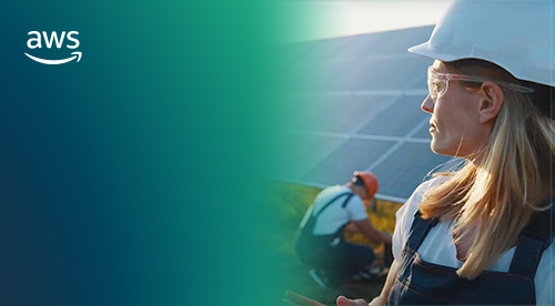 Two people with helmets on standing in front of solar panels