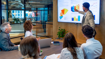 Person giving presentation in front of a group of 5 people