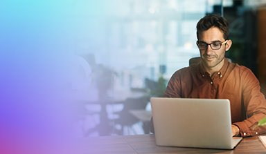 Hombre con gafas escribiendo en una computadora port&aacute;til