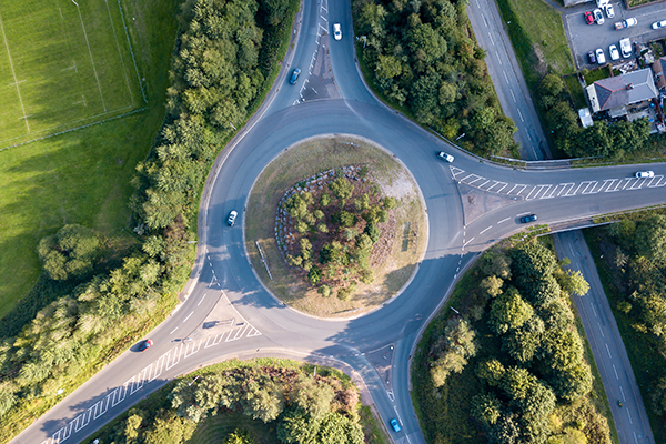 Top down aerial view of a traffic roundabout on a main road in an urban area of the UK