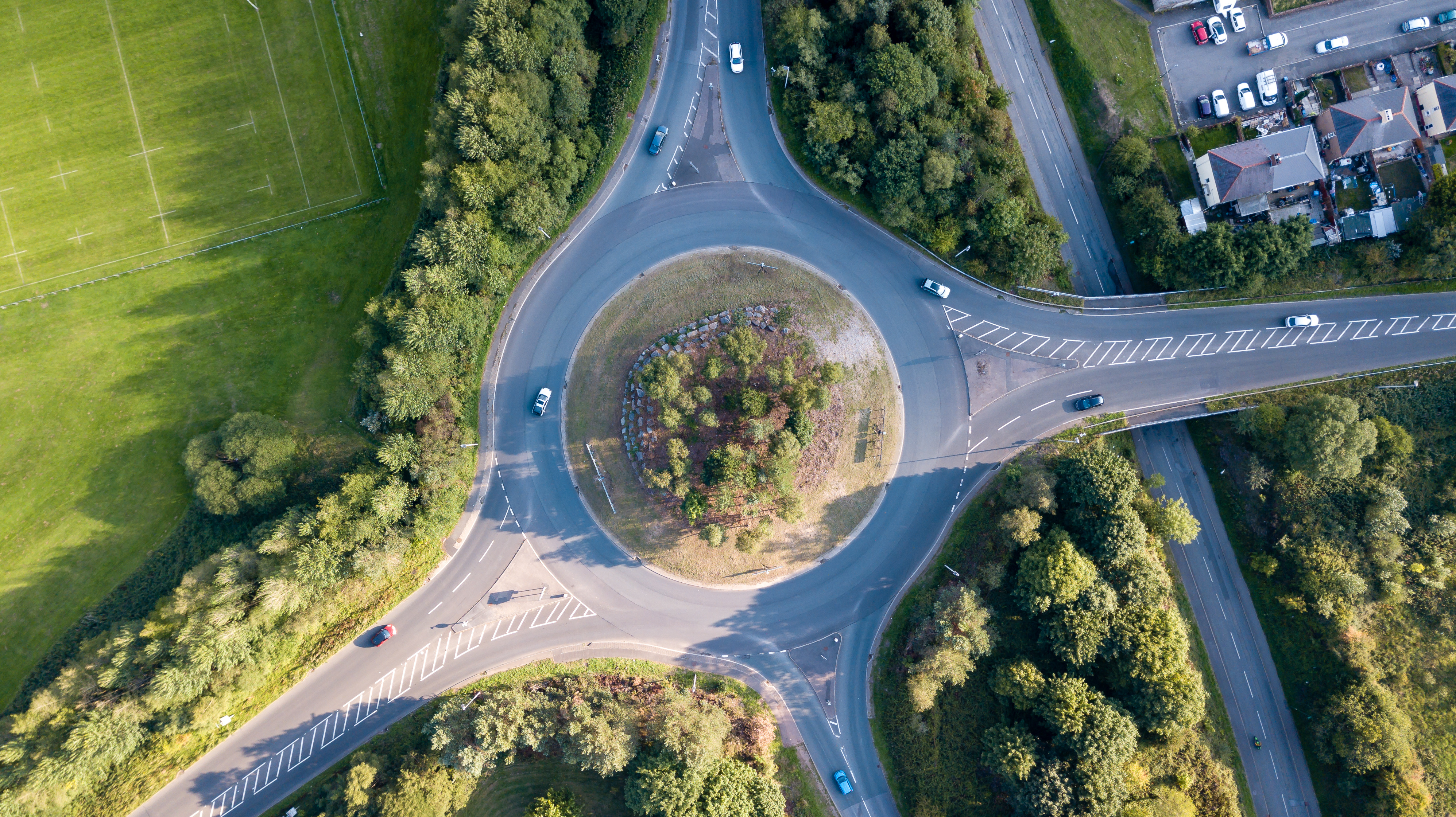 Top down aerial view of a traffic roundabout on a main road in an urban area of the UK