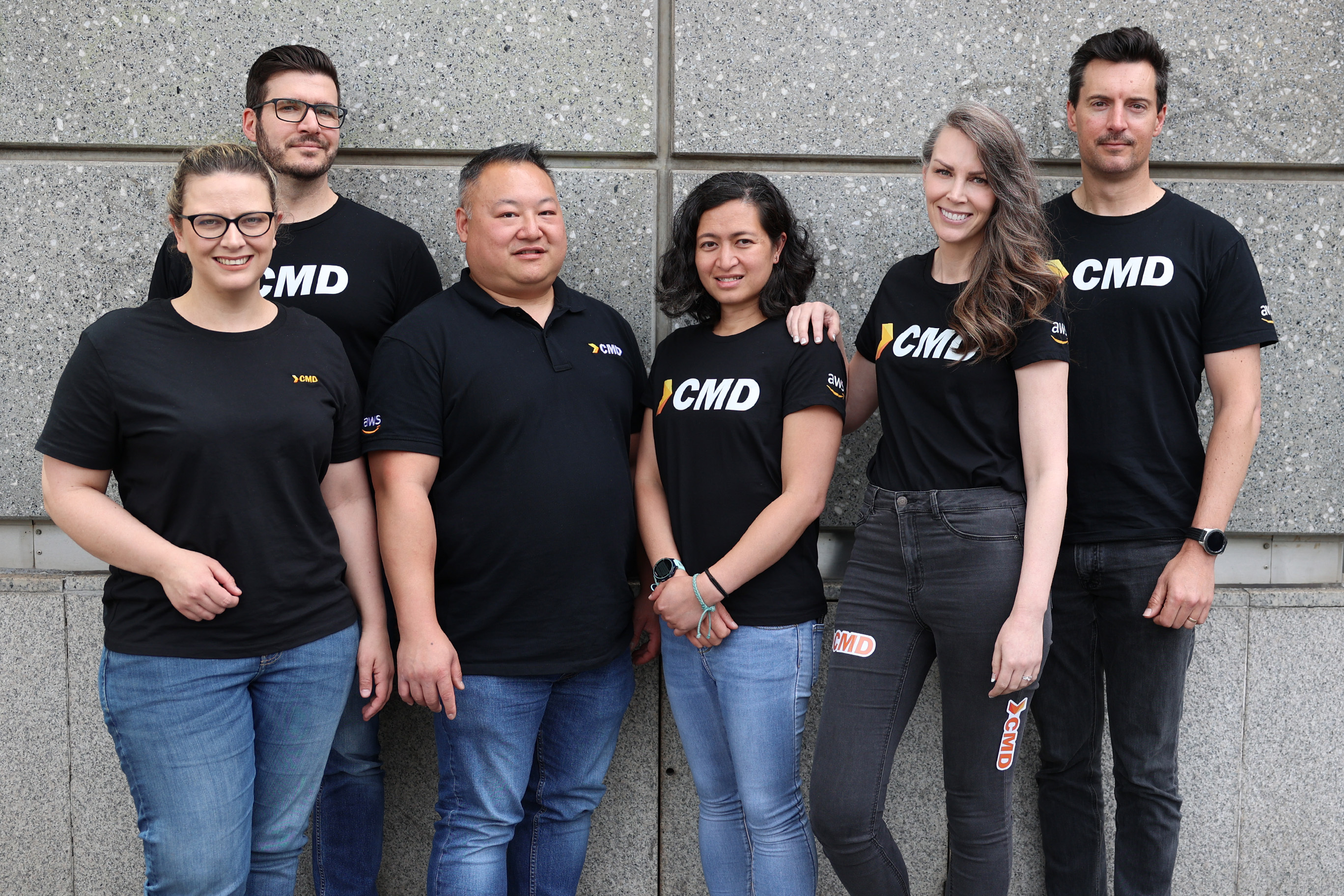 Group of  six CMD employees in matching black shirts with company logo.