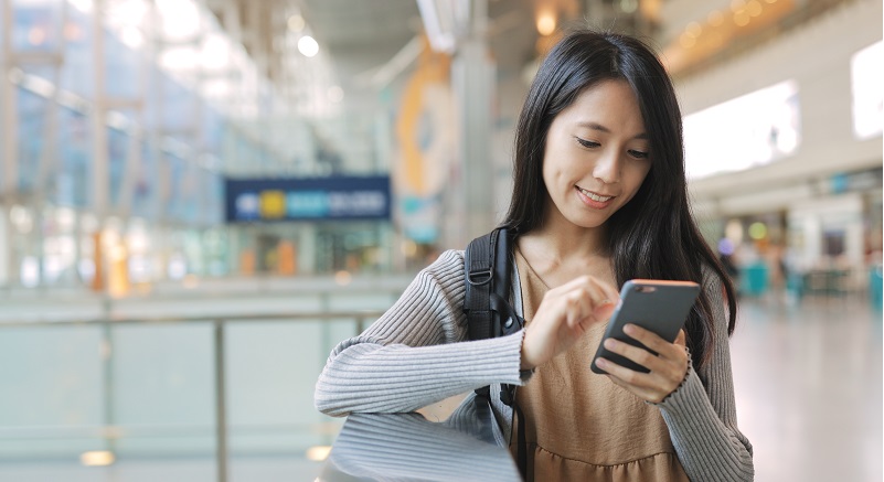 Woman working on mobile phone in the station