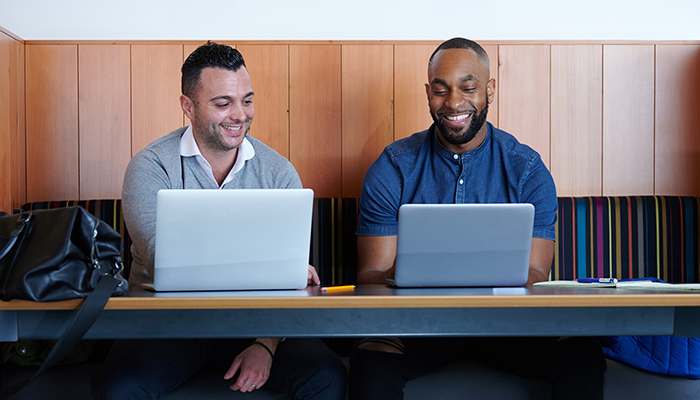 Dois homens em laptops