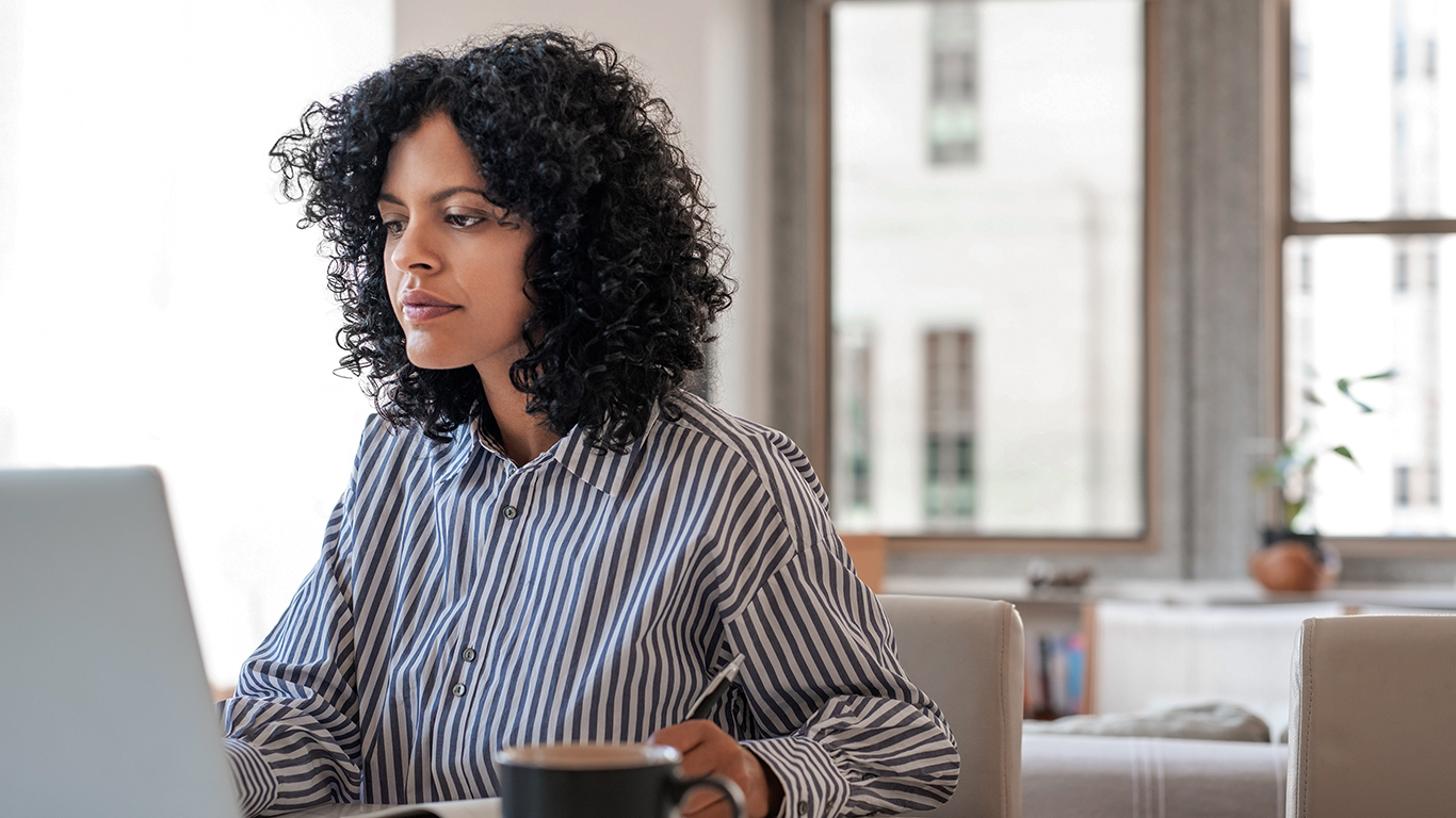 Uma mulher sentada &agrave; mesa com um laptop e fazendo um treinamento da AWS para a fun&ccedil;&atilde;o de arquiteta