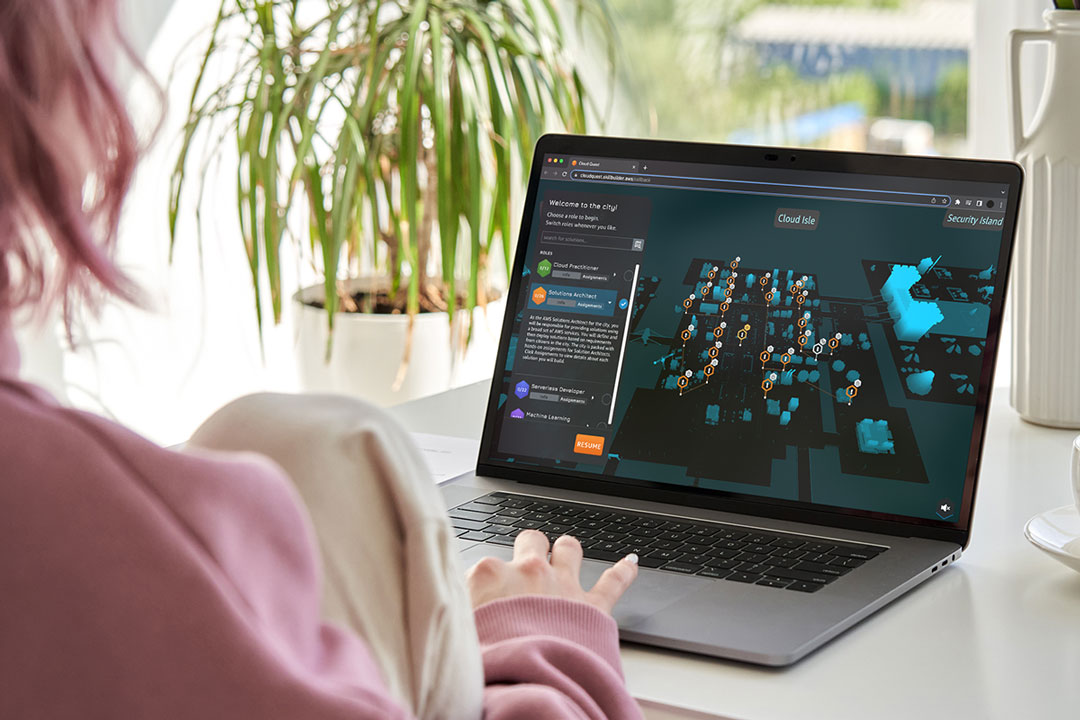 Una persona con pelo rosa y sudadera de ese mismo color juega a AWS Cloud Quest en un portátil