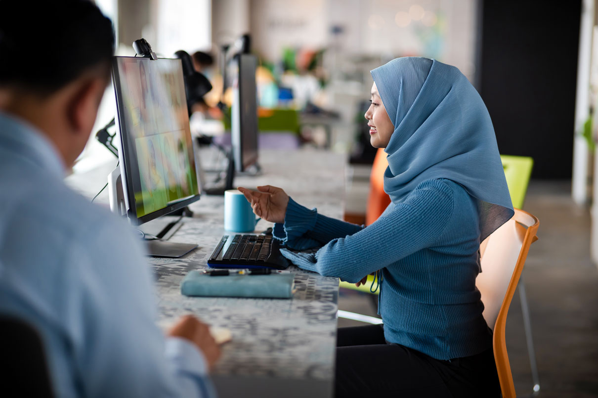 Wanita yang mengenakan jilbab sedang mengikuti kursus Kelas Digital AWS di desktop